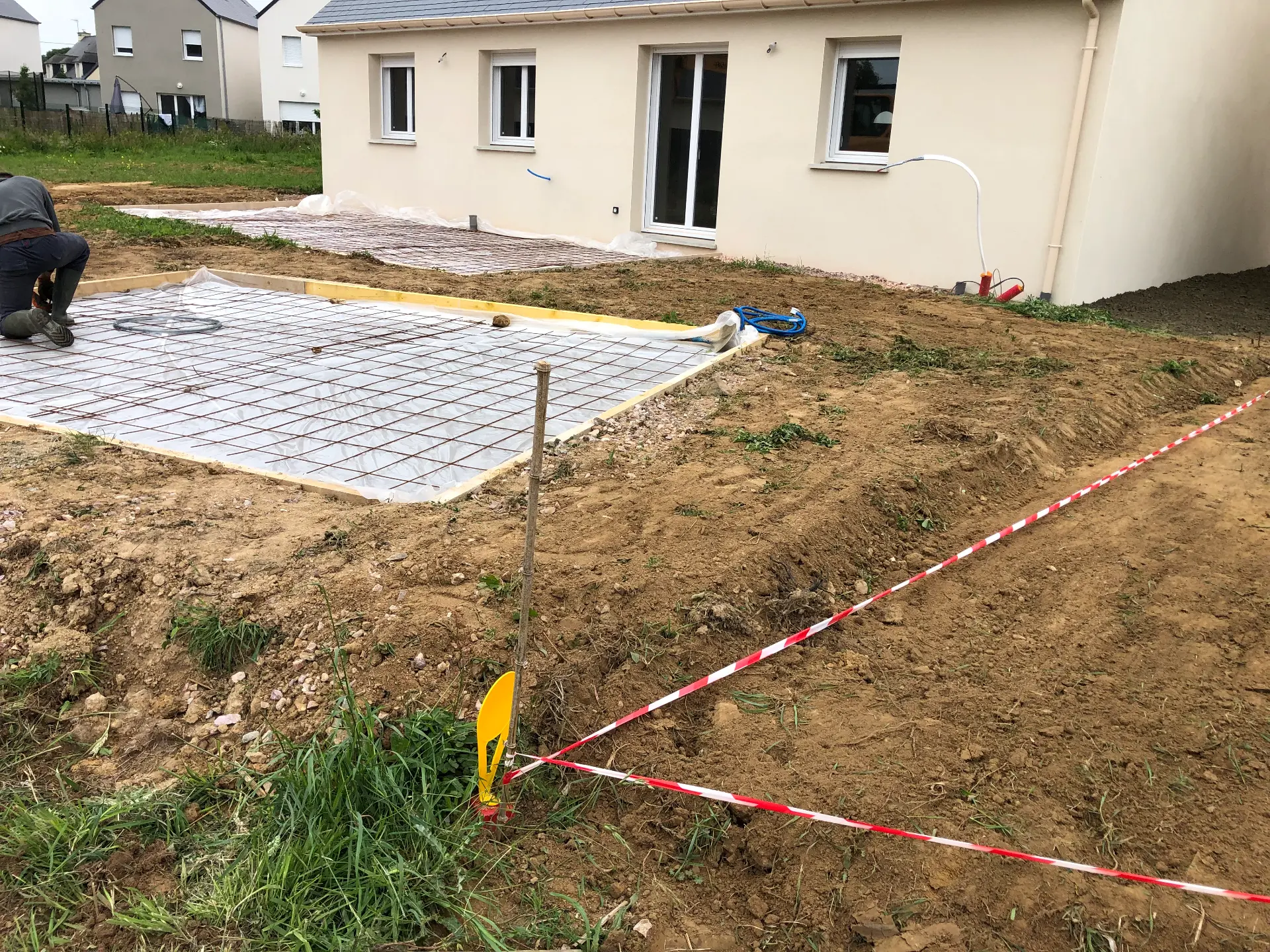 Coffrage bois et treillis métallique préparés pour une dalle béton dans un jardin